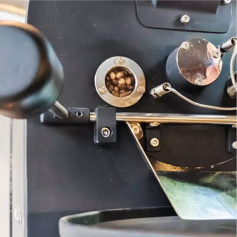 Close-up biji kopi sedang di-roasting di mesin profesional, menunjukkan kualitas biji kopi pilihan dari supplier biji kopi pilihan Gemi.